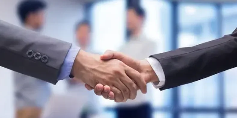 Dua orang berjabat tangan untuk kesepakatan bersama