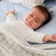 seorang bayi sedang tidur sambil tersenyum