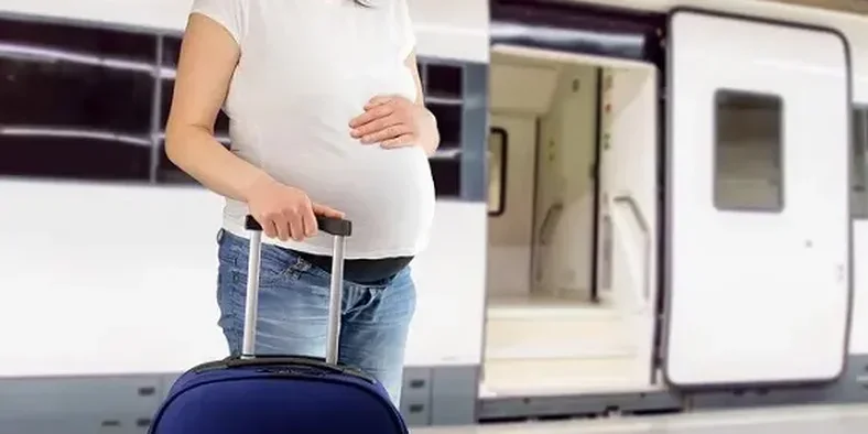 ibu hamil sedang membawa koper