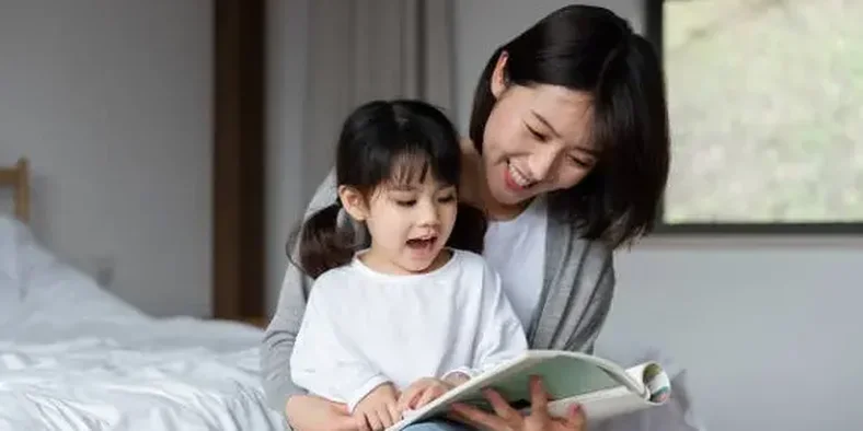 Anak belajar membaca bersama ibunya