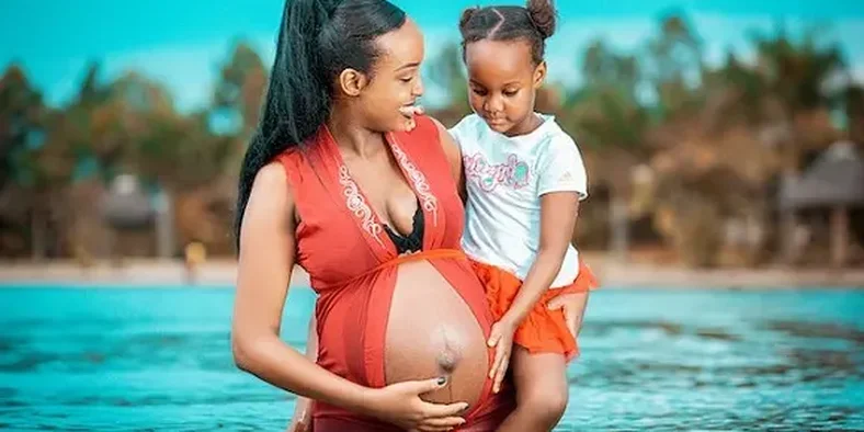 ibu hamil menggendong anak perempuan