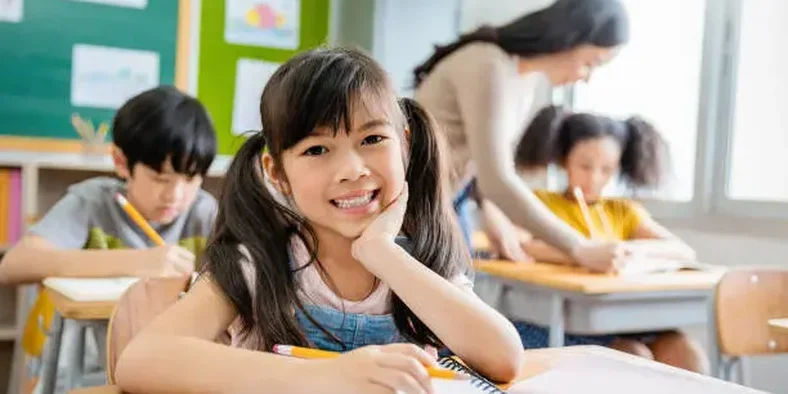 Anak perempuan belajar di sekolah tersenyum