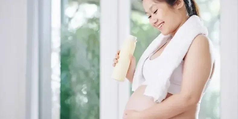 Ibu hamil memegang botol minuman