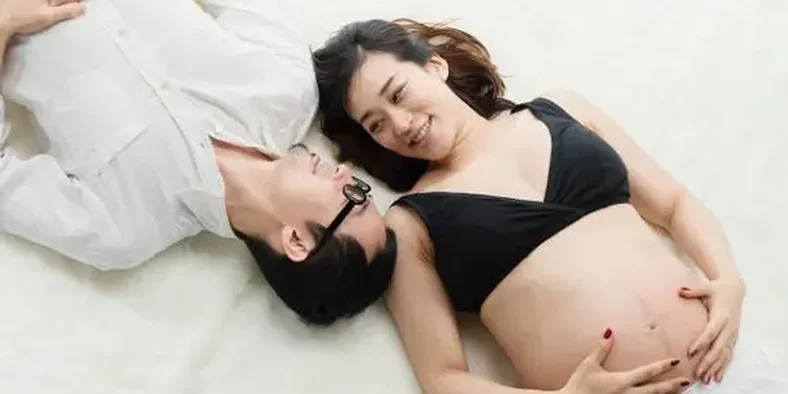 Suami dan istrinya yang sedang hamil di atas kasur