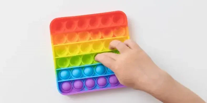 Anak kecil bermain pop it rainbow