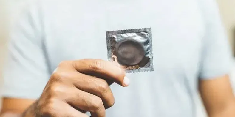 Pria memegang kondom