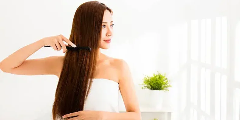 Wanita menyisir rambutnya yang panjang