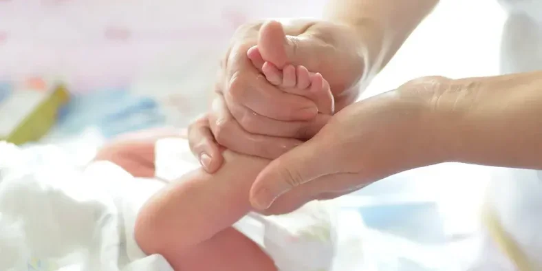 ibu memijat kaki bayi
