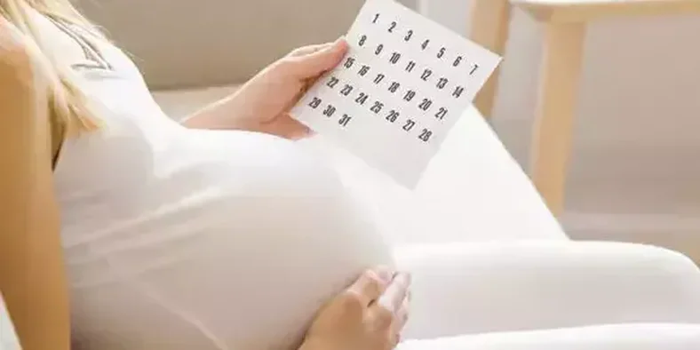 Ibu hamil memegang kalender HPL