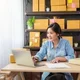 Wanita Asia sedang menggunakan laptop untuk menjalankan bisnis online