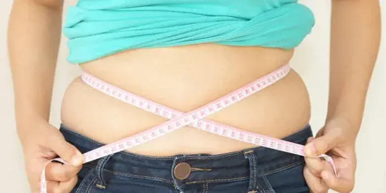 Perempuan sedang mengukur lingkar perut
