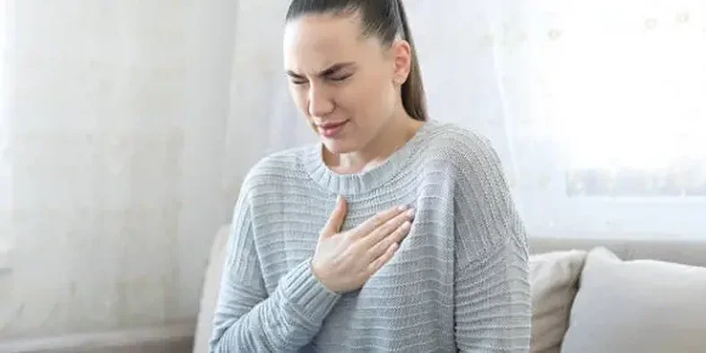 Wanita sedang memegang dadanya karena asma kambuh