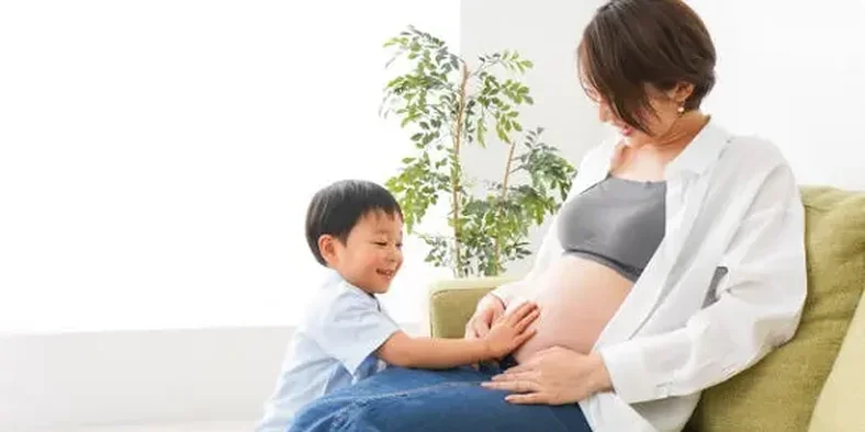 Seorang anak dan ibunya yang sedang hamil