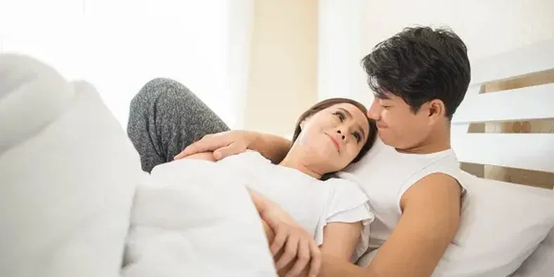 Suami istri tidur di atas kasur