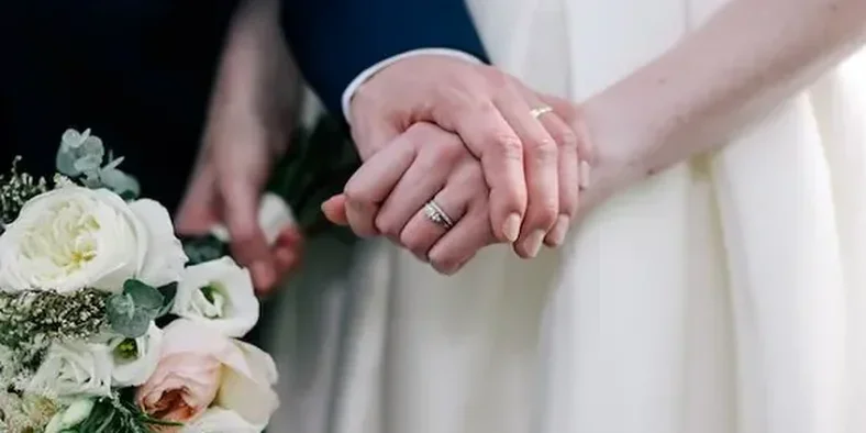 tangan pria dan tangan perempuan memakai cincin pernikahan