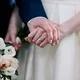 tangan pria dan tangan perempuan memakai cincin pernikahan