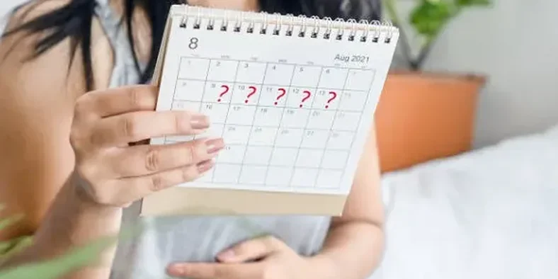 Seorang wanita sedang memegang kalender menstruasi