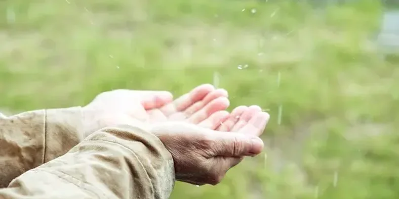 tangan menampung air hujan