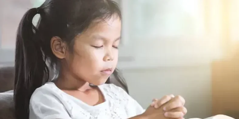 Anak sedang berdoa kepada Tuhan Yesus