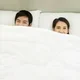 Pasangan suami istri sedang bercinta di atas kasur