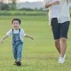 anak kecil berlari bersama ayah di lapangan