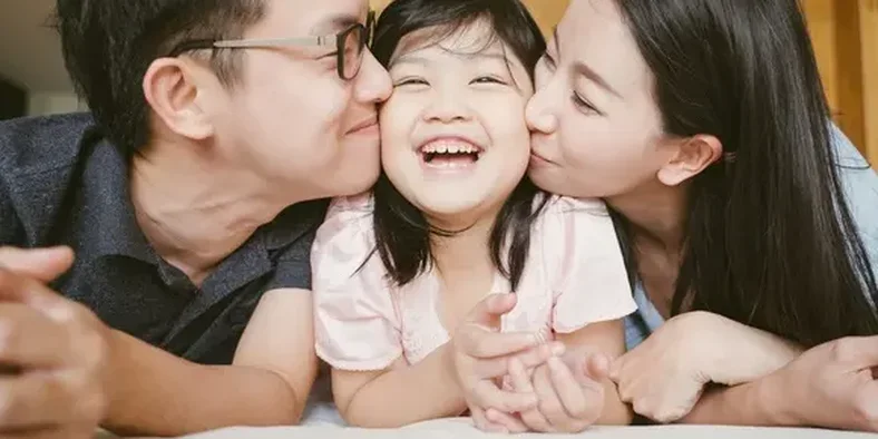 orang tua mencium anak perempuannya