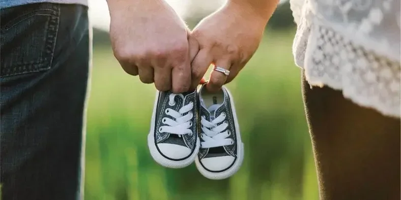 Pasangan kekasih memegang sepatu bayi