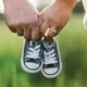 Pasangan kekasih memegang sepatu bayi