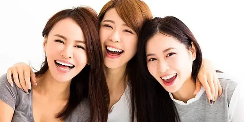 Tiga wanita bersahabat dan tersenyum bahagia