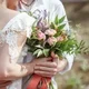 Pasangan menikah memegang bunga