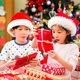 Dua anak sedang membuka kado natal