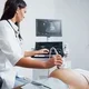 seorang dokter sedang memeriksa janin wanita hamil