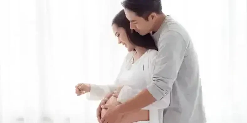 Suami memegang perut hamil istrinya