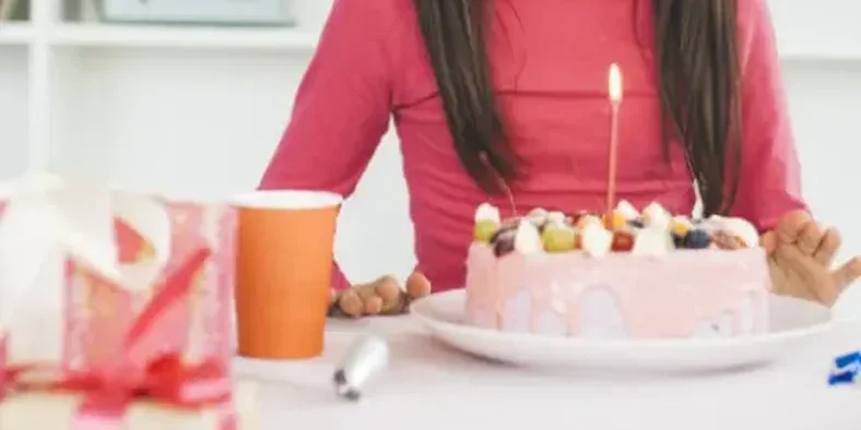 Anak perempuan meniup lilin ulang tahun