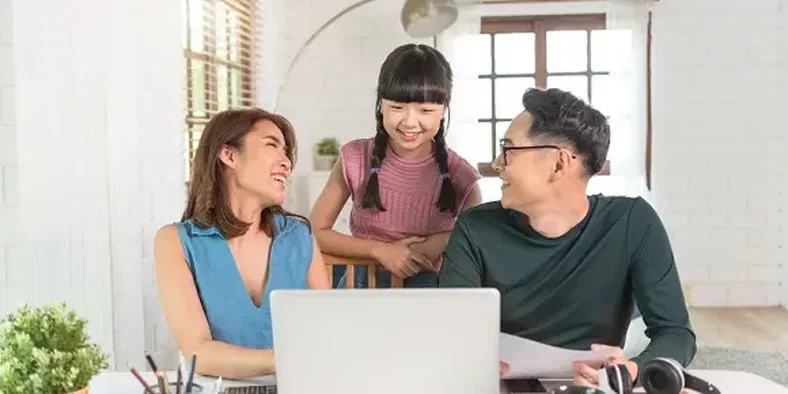 Ibu, ayah dan anak sedang menonton film di laptop