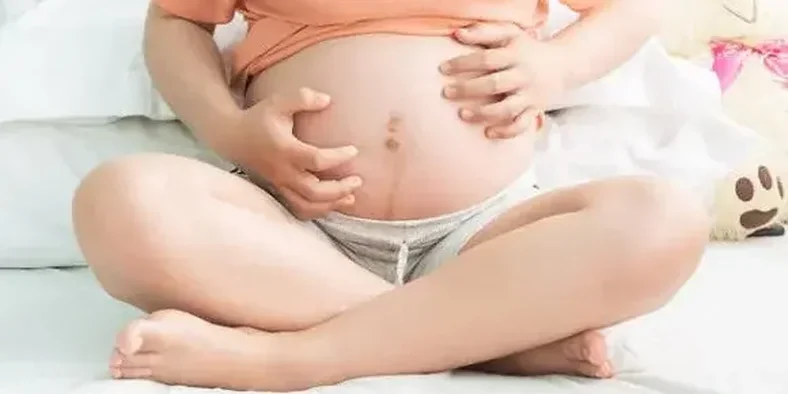 seorang ibu hamil menyentuh perutnya