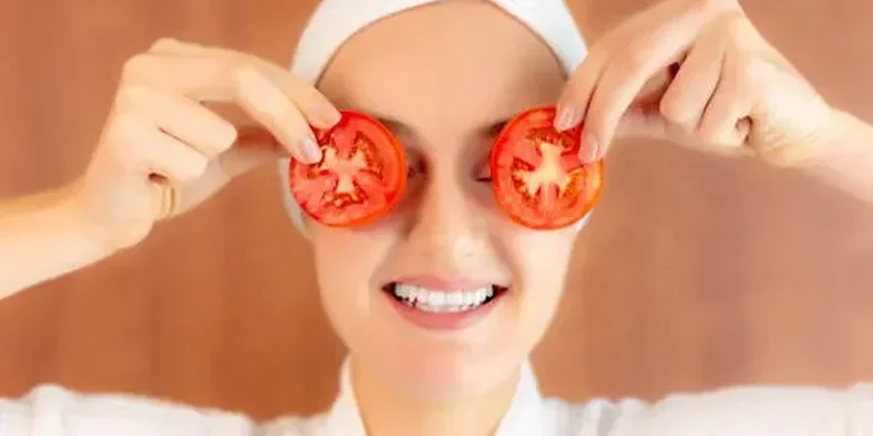 Wanita menggunakan tomat untuk perawatan wajah