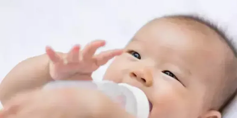 Bayi laki-laki sedang meminum susu dari dot