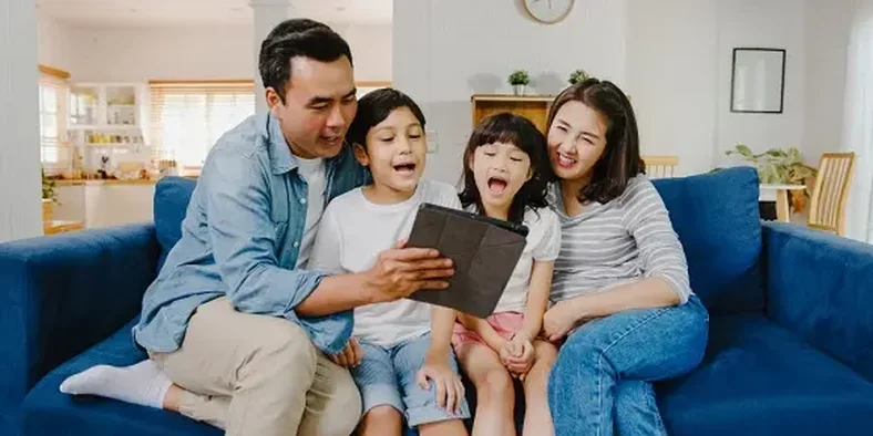 keluarga bahagia sedang menonton ipad