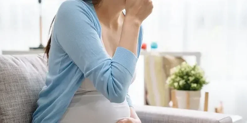 ibu hamil menutup mulutnya karena mual