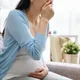 ibu hamil menutup mulutnya karena mual