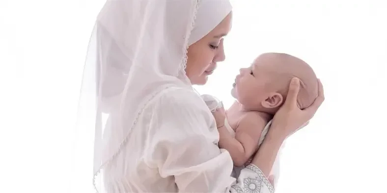 Wanita muslim menggendong bayi laki-laki baru lahir