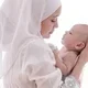 Wanita muslim menggendong bayi laki-laki baru lahir