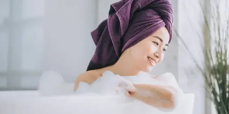seorang wanita mandi dengan handuk di kepala