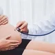 dokter memeriksa perut ibu hamil