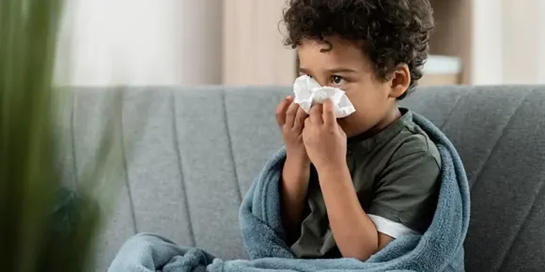 anak kecil sedang mengelap hidungnya dengan tisu