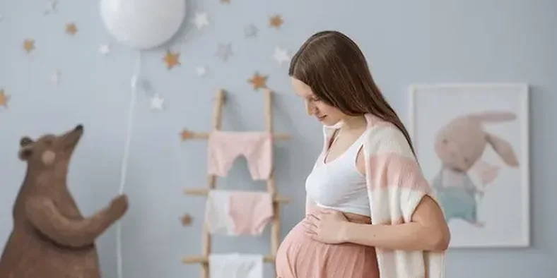 ibu hamil sedang memegang perutnya