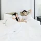Pasangan suami istri bangun tidur dengan bahagia