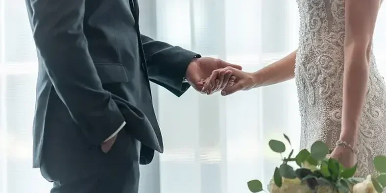 pasangan yang baru saja menikah sedang berpengan tangan