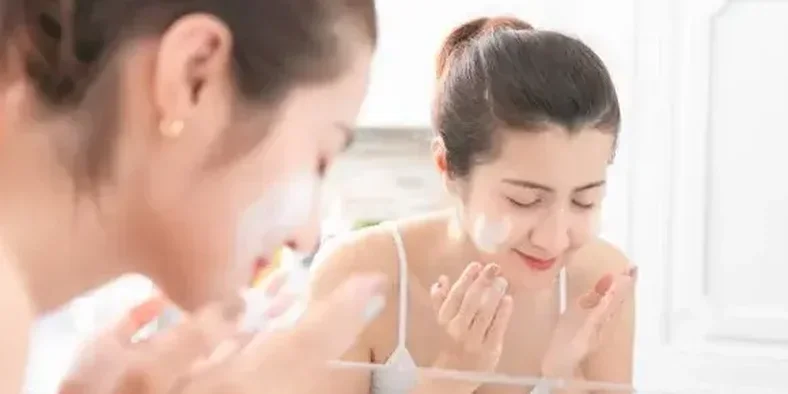 Seorang wanita sedang membersihkan wajah dengan sabun muka
